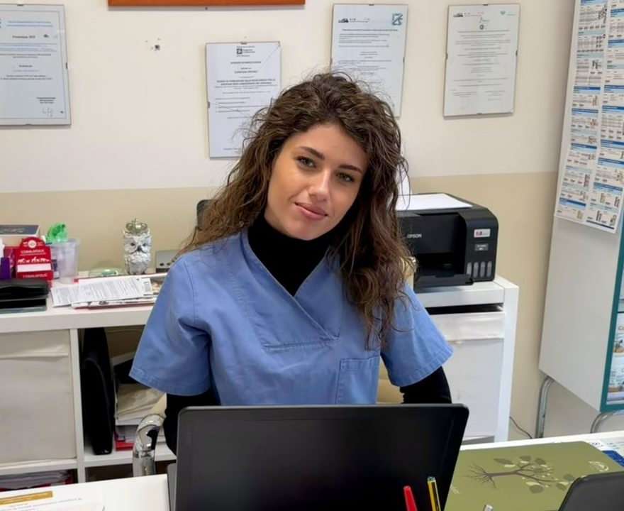 Fabiana Vignoni alla scrivania con il computer, davanti a una parete con attestati