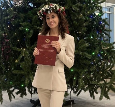 Fabiana il giorno della laurea, con la corona d'alloro e la tesi in mano (apri Instagram)